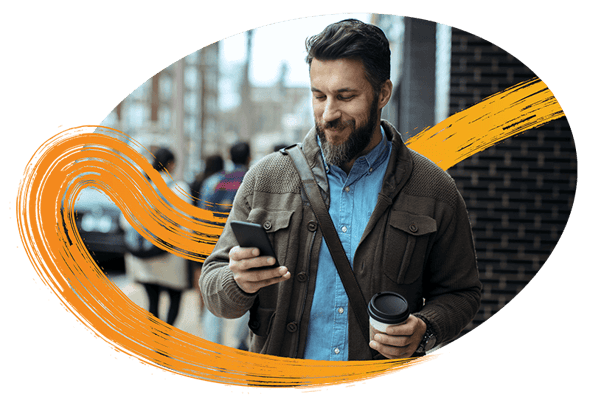 man-on-mobile-in-city-holding-to-go-coffee