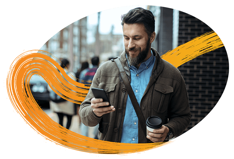 man-on-mobile-in-city-holding-to-go-coffee