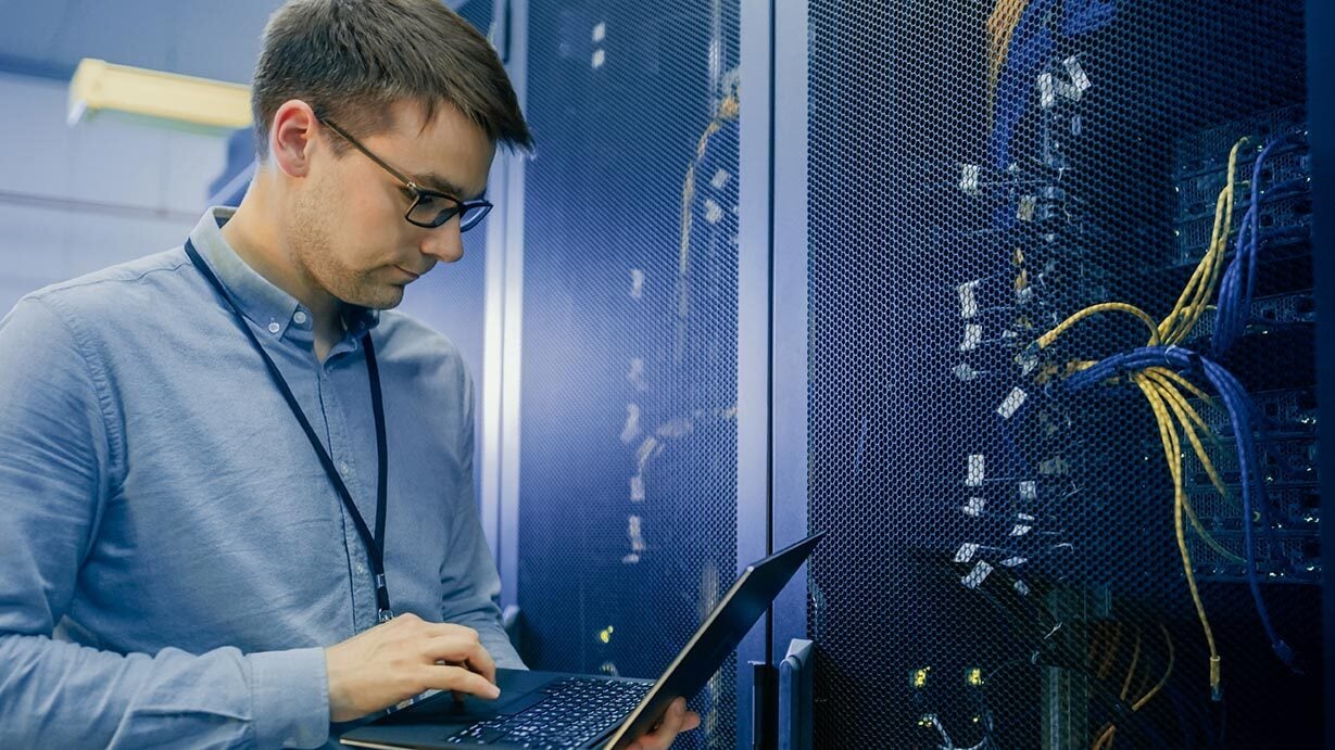 man-on-laptop-in-data-center